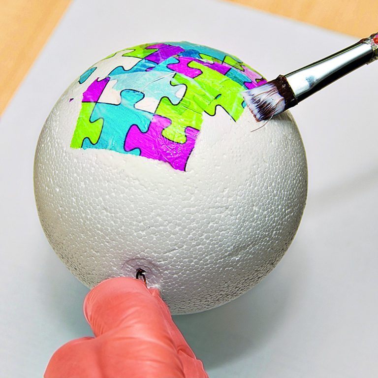 Natrhané kousky papíru na decoupage nalepte na polystyrenovou kouli. Můžete použít i různé druhy (zbytky). Na létajícím balonu to vypadá dobře, různobarevné kousky připomínají záplaty.