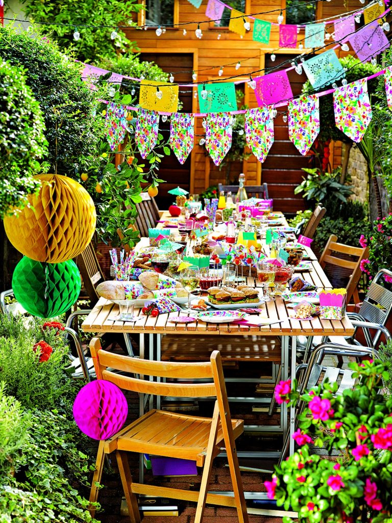 Atmosféru garden party s bohatě prostřeným stolem dotvoří lampiony, světelné řetězy a vlaječky.