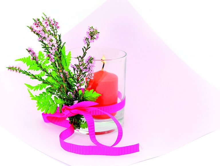 Obyčejný skleněný svícen zkrášlíte, když ho ozdobíte snítkou vřesu, kterou přivážete stužkou sladěnou s tónem květů.