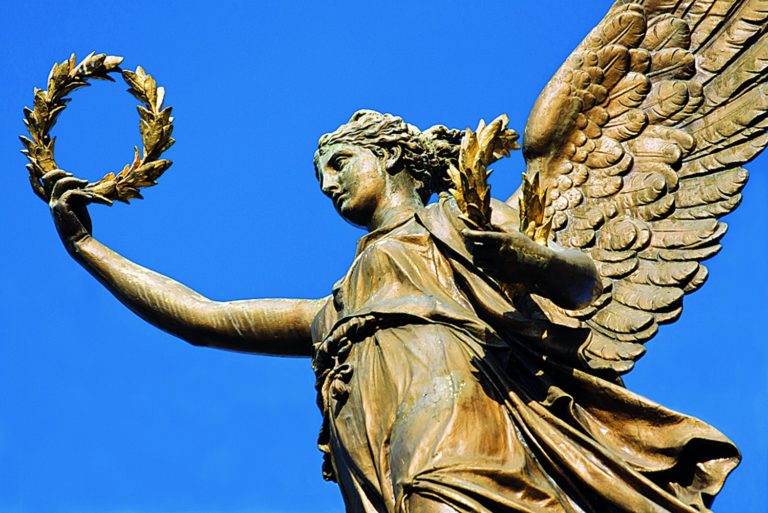 Vavřín zdobil hlavy císařů, vítězů i umělců. Před Rudolfinem drží vavřínový věnec zlatý anděl.